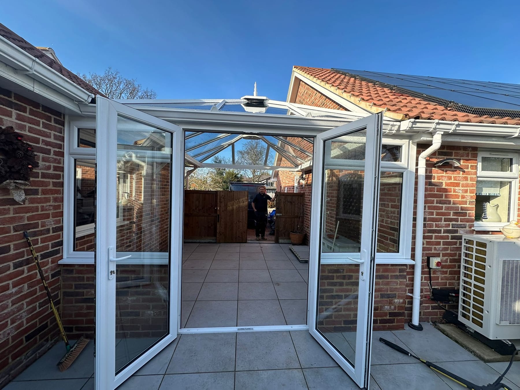 White aluminium bifold doors and roof lantern on a brick bungalow