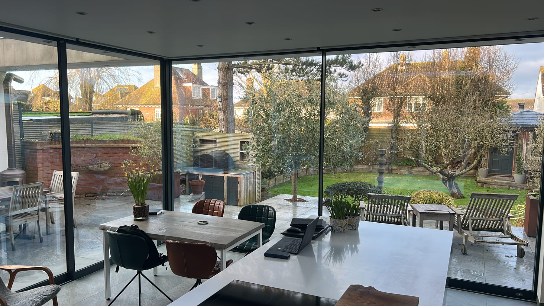 Slim aluminium sliding doors opening a kitchen-diner onto the garden