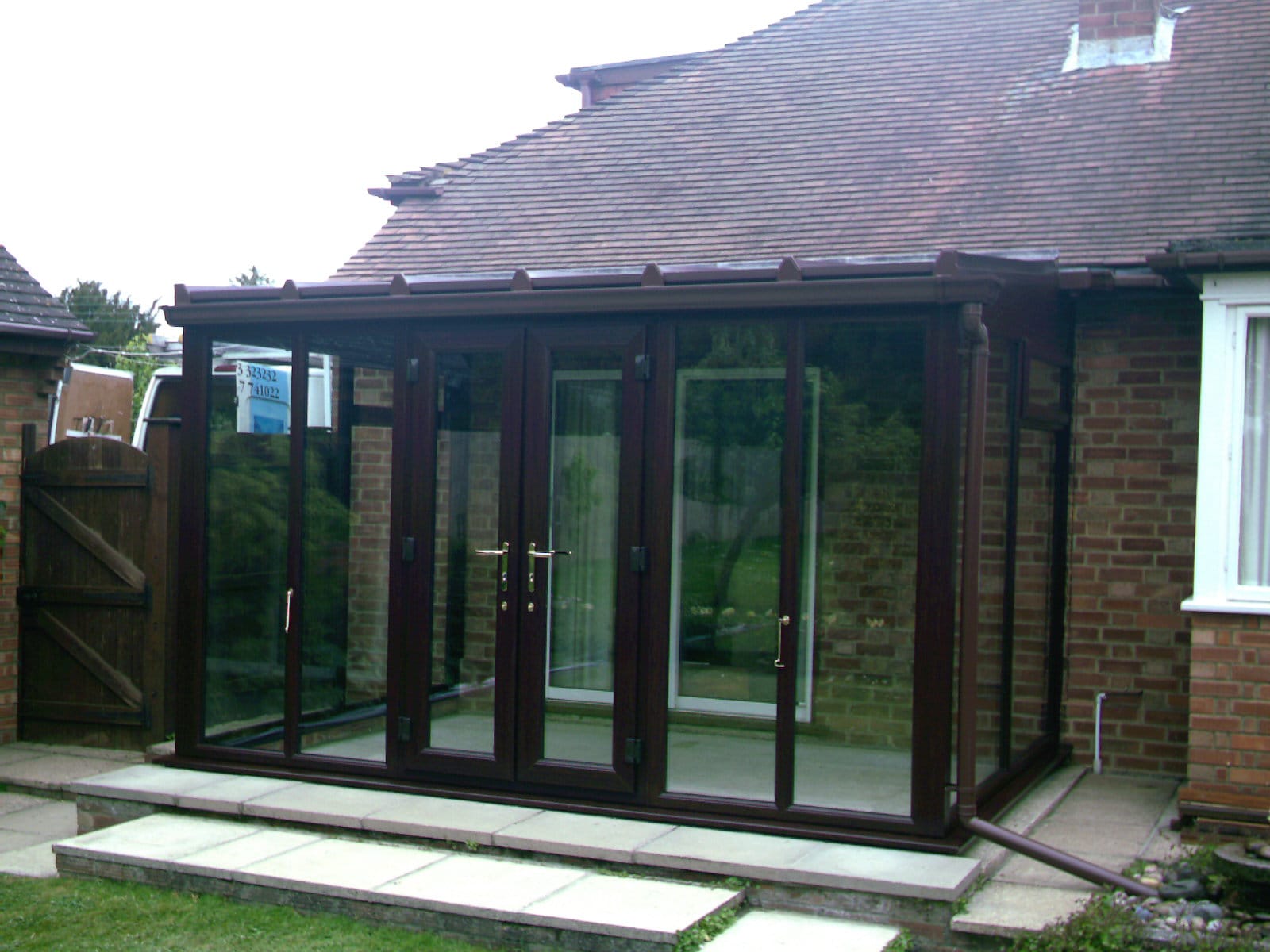 Rosewood-effect uPVC conservatory with French doors on a bungalow