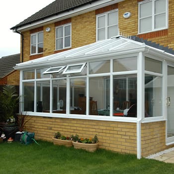 White uPVC Edwardian conservatory on a yellow-brick house