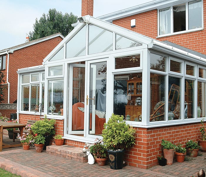 White uPVC gable-end conservatory on a brick house