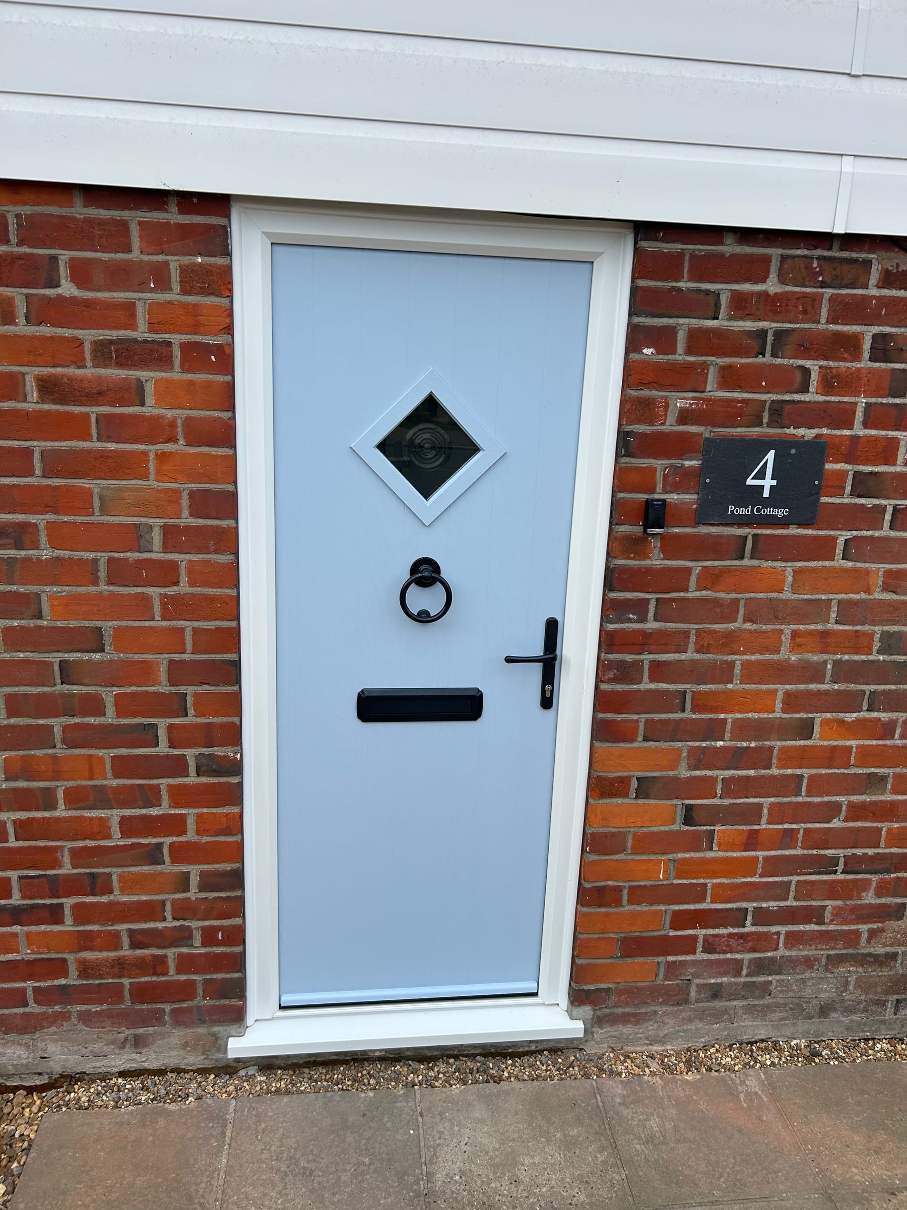 White uPVC front door with diamond glazing on a red-brick house