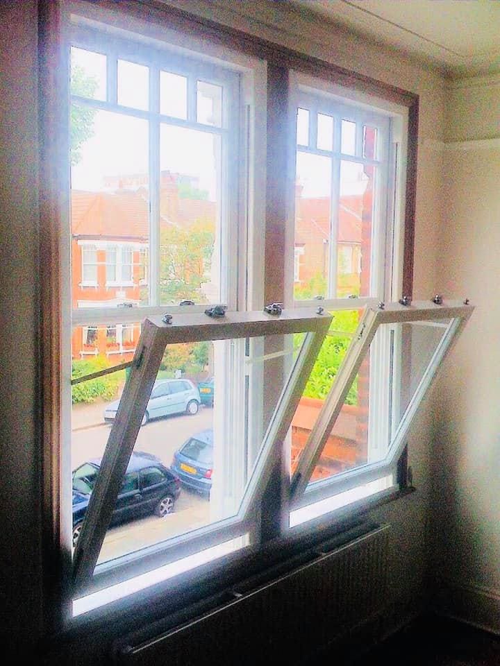 White uPVC sliding sash window tilted open for cleaning